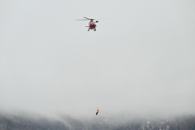A rescuer is airlifted as a slope attendant injured himself during the Women's Downhill event of FIS Alpine Skiing World Cup in Tarvisio, Italy on January 17, 2026. (Photo by Marco BERTORELLO / AFP)