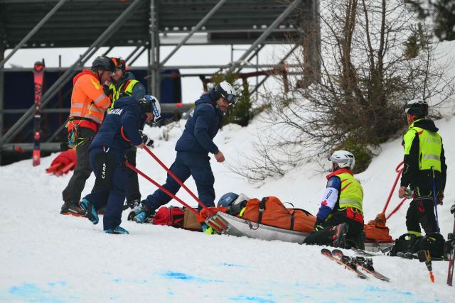 Police and rescuers help a slope attendant after he injured himself during the Women's Downhill event of FIS Alpine Skiing World Cup in Tarvisio, Italy on January 17, 2026. (Photo by Marco BERTORELLO / AFP)