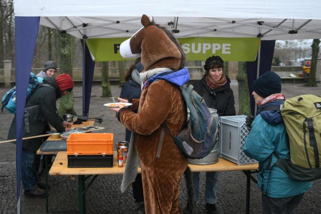 A protesters wearing a horse coszume has a bite to eat during a rally titled "We are fed up!" and demanding a socially just agricultural transition, in Berlin on January 17, 2026. (Photo by RALF HIRSCHBERGER / AFP)