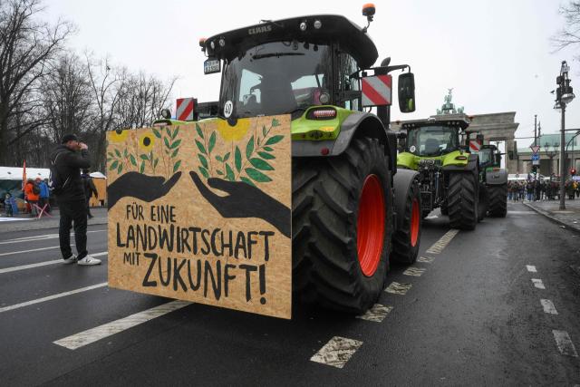 Farmers park their tractors in front of the Brandenburg Gate as they take part in a demonstration titled "We are fed up!" and demanding a socially just agricultural transition, in Berlin on January 17, 2026. (Photo by RALF HIRSCHBERGER / AFP)