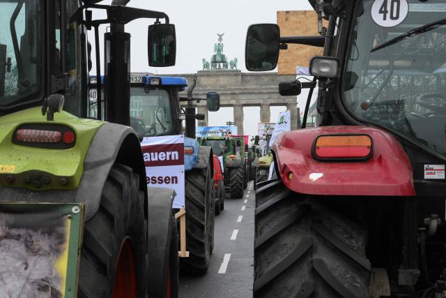 Farmers park their tractors in front of the Brandenburg Gate as they take part in a demonstration titled "We are fed up!" and demanding a socially just agricultural transition, in Berlin on January 17, 2026. (Photo by RALF HIRSCHBERGER / AFP)