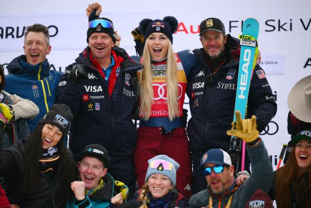 US' Lindsey Vonn, third, poses with her team during the podium ceremony of the Women's Downhill event of FIS Alpine Skiing World Cup in Tarvisio, Italy on January 17, 2026. Italy's Nicol Delago won the race ahead of Germany's Kira Weidle, second, and US' Lindsey Vonn, third. (Photo by Marco BERTORELLO / AFP)