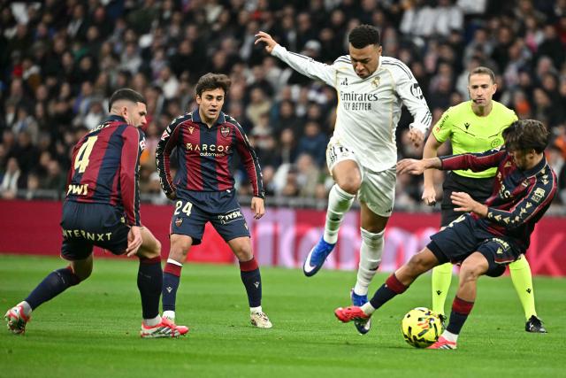 Levante's Spanish midfielder #12 Unai Vencedor (R) tackles Real Madrid's French forward #10 Kylian Mbappe during the Spanish league football match between Real Madrid CF and Levante UD at Santiago Bernabeu Stadium in Madrid on January 17, 2026. (Photo by Javier SORIANO / AFP)