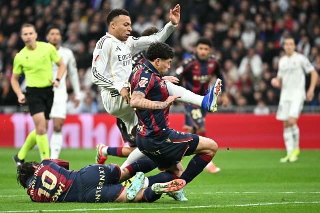 Real Madrid's French forward #10 Kylian Mbappe (C) fights for the ball with Levante's Spanish midfielder #10 Pablo Martinez and Levante's Uruguayan defender #03 Alan Matturro (R) during the Spanish league football match between Real Madrid CF and Levante UD at Santiago Bernabeu Stadium in Madrid on January 17, 2026. (Photo by Javier SORIANO / AFP)