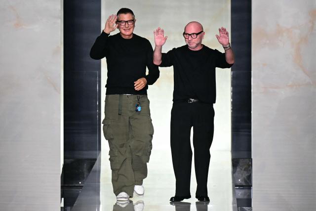 TOPSHOT - Italian designers Stefano Gabbana and Domenico Dolce (R) greet the audience at the end of the Dolce & Gabbana collection show at Milan's fashion week for the Men's Fall/Winter 2026-2027, on January 17, 2026 in Milan. (Photo by Stefano RELLANDINI / AFP)