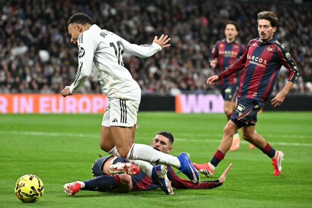 Levante's Spanish defender #04 Adrian De La Fuente fouls Real Madrid's French forward #10 Kylian Mbappe during the Spanish league football match between Real Madrid CF and Levante UD at Santiago Bernabeu Stadium in Madrid on January 17, 2026. (Photo by Javier SORIANO / AFP)