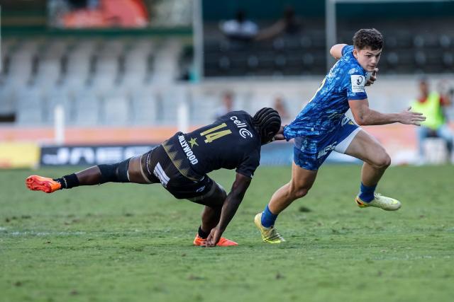 TOPSHOT - Sharks' South African wing Yaw Penxe (L) attempts to tackle Clermont’s French fullback Axel Guillaud (R) during the European Champions Cup rugby union match between Sharks and Clermont in Durban on January 17, 2026. (Photo by PHILL MAGAKOE / AFP)