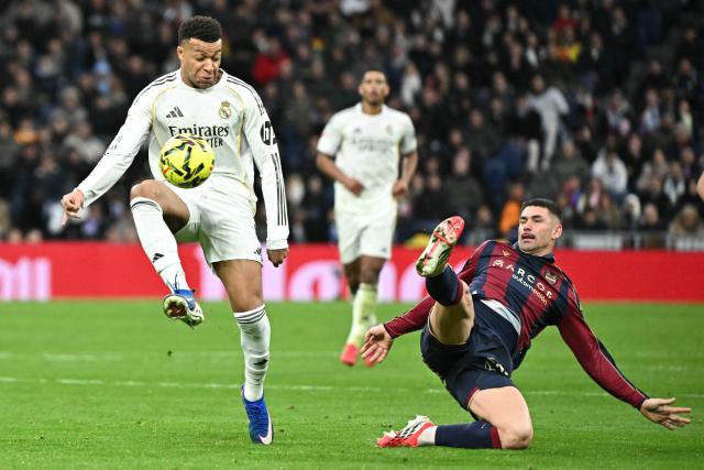 TOPSHOT - Real Madrid's French forward #10 Kylian Mbappe and Levante's Spanish defender #04 Adrian De La Fuente fight for the ball during the Spanish league football match between Real Madrid CF and Levante UD at Santiago Bernabeu Stadium in Madrid on January 17, 2026. (Photo by Javier SORIANO / AFP)