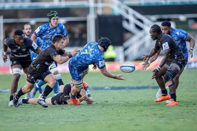 Clermont's French flanker Lucas Dessaigne (C) passes the ball as he is tackled during the European Champions Cup rugby union match between Sharks and Clermont in Durban on January 17, 2026. (Photo by PHILL MAGAKOE / AFP)