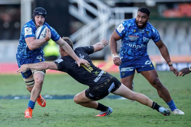 Clermont's French flanker Lucas Dessaigne (L) is tackled by Sharks' South African centre Le Roux Malan (C) during the European Champions Cup rugby union match between Sharks and Clermont in Durban on January 17, 2026. (Photo by PHILL MAGAKOE / AFP)