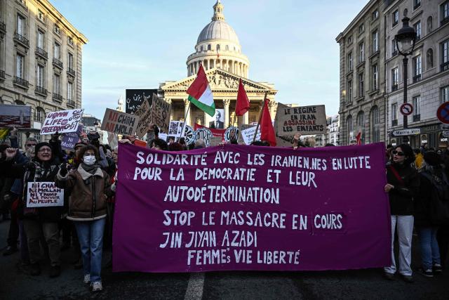 Protesters hold a placard reading "Solidarity with Iranian women in their struggle for democracy and self-determination" during a rally in support of the Iranian people in front of the Pantheon in Paris on January 17, 2026. Protests in Iran have subsided after a crackdown that has killed thousands under an internet blackout, monitors said on January 16, a week after the start of the largest demonstrations in years challenging the country's theocratic system. Protests sparked by economic grievances started with a shutdown in the Tehran bazaar on December 28, 2025 but turned into a mass movement demanding the removal of the clerical system that has ruled Iran since the 1979 revolution. (Photo by JULIEN DE ROSA / AFP)