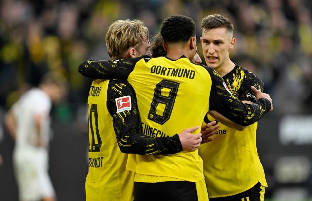 Dortmund's German midfielder #10 Julian Brandt (L) celebrates with Dortmund's German midfielder #08 Felix Nmecha (C) and Dortmund's German defender #04 Nico Schlotterbeck (R) after scoring the 1-0 goal during the German first division Bundesliga football match between BVB Borussia Dortmund and FC St Pauli in Dortmund, western Germany, on January 17, 2026. (Photo by INA FASSBENDER / AFP) / DFL REGULATIONS PROHIBIT ANY USE OF PHOTOGRAPHS AS IMAGE SEQUENCES AND/OR QUASI-VIDEO