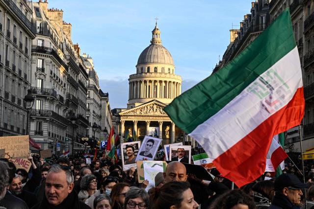 Protesters hold banners and Iranian flags during a rally in support of the Iranian people in front of the Pantheon in Paris on January 17, 2026. Protests in Iran have subsided after a crackdown that has killed thousands under an internet blackout, monitors said on January 16, a week after the start of the largest demonstrations in years challenging the country's theocratic system. Protests sparked by economic grievances started with a shutdown in the Tehran bazaar on December 28, 2025 but turned into a mass movement demanding the removal of the clerical system that has ruled Iran since the 1979 revolution. (Photo by JULIEN DE ROSA / AFP)