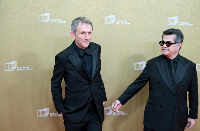Iranian director Jafar Panahi (R) and French producer Philippe Martin arrive for the European Film Awards on January 17, 2026 in Berlin. (Photo by RALF HIRSCHBERGER / AFP)
