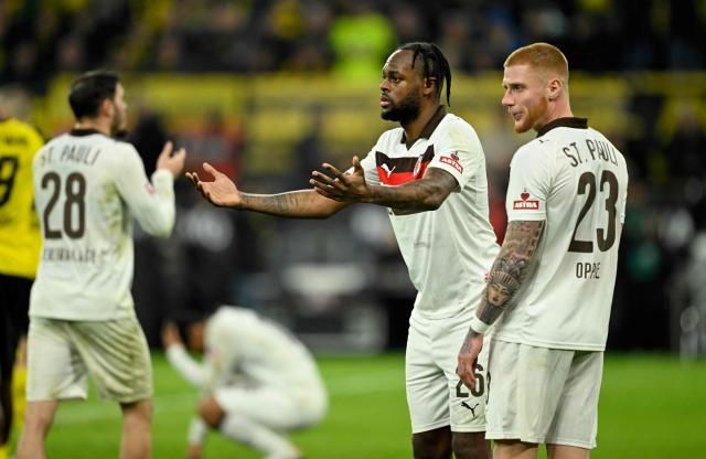St Pauli's German defender #23 Louis Oppie (R)and St Pauli's English forward #26 Ricky-Jade Jones (2nd R) react as Dortmund is given a penalty shot during the German first division Bundesliga football match between BVB Borussia Dortmund and FC St Pauli in Dortmund, western Germany, on January 17, 2026. (Photo by INA FASSBENDER / AFP) / DFL REGULATIONS PROHIBIT ANY USE OF PHOTOGRAPHS AS IMAGE SEQUENCES AND/OR QUASI-VIDEO