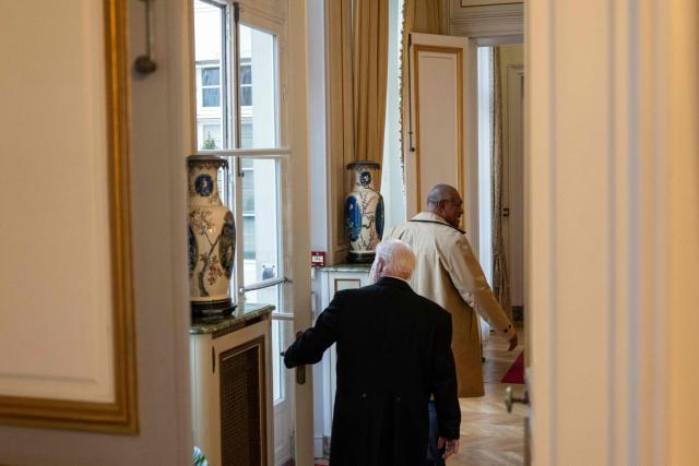 A bulter opens the door for President of the Government of New Caledonia Alcide Ponga (R) in a hall ahead of a meeting with a delegation of representatives of New-Caledonia at France's Overseas Ministry in Paris on January 17, 2026. On January 16, France's President opened a new round of discussions on the institutional future of New Caledonia, stating his desire to move forward “without forcing the issue but without paralysis,” despite the absence of the main independence movement. (Photo by Martin LELIEVRE / AFP)
