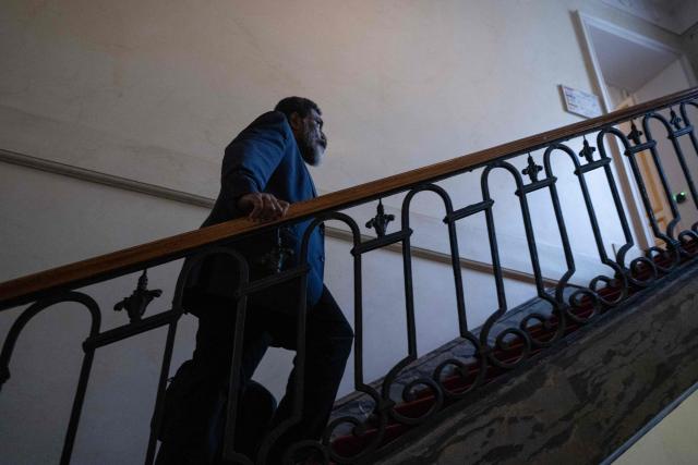 Member of the Palika (Kanak Liberation party) and L'UNI (National Union for Independance) coalition Adolphe Digouй walks up stairs ahead of a meeting with a delegation of representatives of New-Caledonia at France's Overseas Ministry in Paris on January 17, 2026. On January 16, France's President opened a new round of discussions on the institutional future of New Caledonia, stating his desire to move forward “without forcing the issue but without paralysis,” despite the absence of the main independence movement. (Photo by Martin LELIEVRE / AFP)