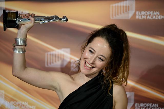 Spanish art director Laia Ateca holds up her "European Production Designer" trophy she was given for the movie "Sirat" during the European Film Awards on January 17, 2026 in Berlin. (Photo by RALF HIRSCHBERGER / AFP)