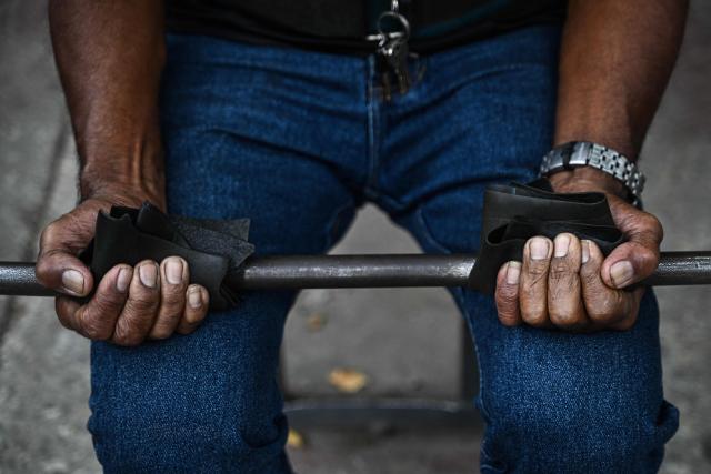 A man exercises at La Candelaria square, an outdoor public gym, in Caracas on January 17, 2026. (Photo by Ronaldo SCHEMIDT / AFP)