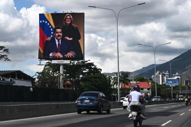 Vehicles drive along the Francisco Fajardo highway, where a billboard displays an image of ousted Venezuelan President Nicolas Maduro and his wife Cilia Flores, in Caracas on January 17, 2026. (Photo by Ronaldo SCHEMIDT / AFP)