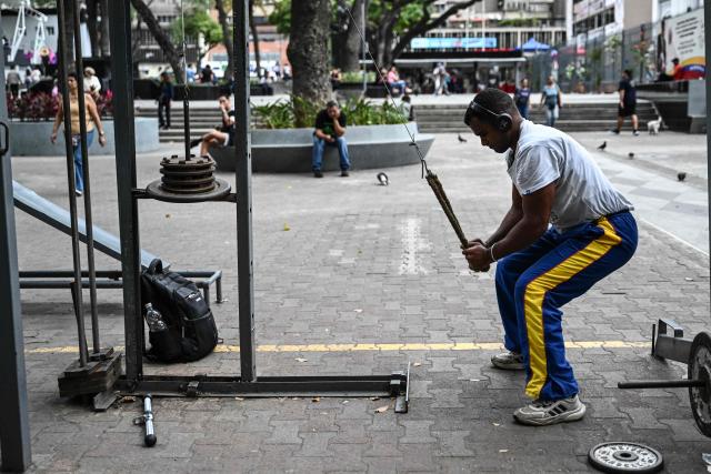 A man exercises at La Candelaria square, an outdoor public gym, in Caracas on January 17, 2026. (Photo by Ronaldo SCHEMIDT / AFP)