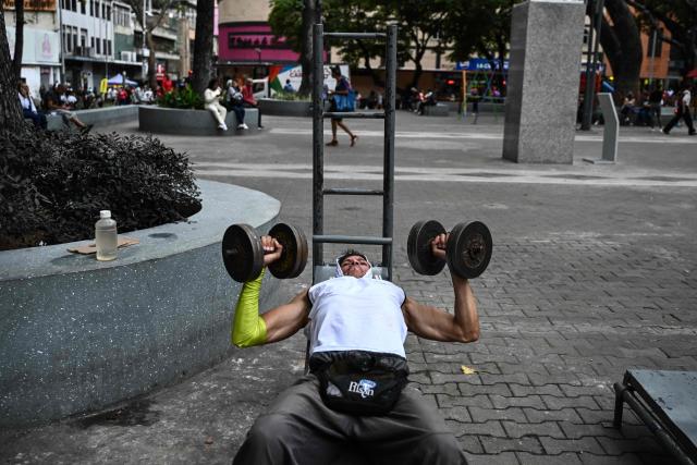 A man exercises at La Candelaria square, an outdoor public gym, in Caracas on January 17, 2026. (Photo by Ronaldo SCHEMIDT / AFP)