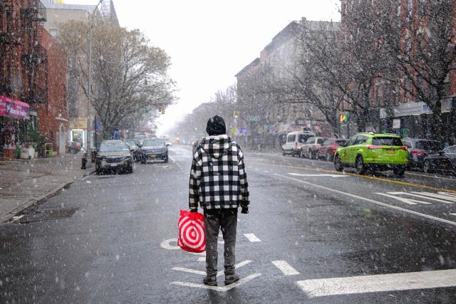 A man stands on the street as it snows in New York on January 17, 2026. (Photo by CHARLY TRIBALLEAU / AFP)