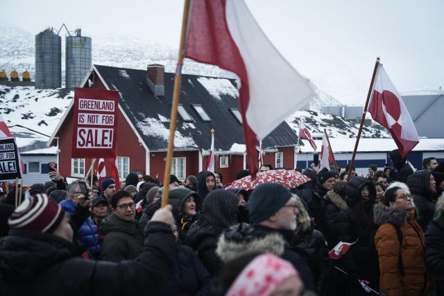 People wave Greenlandic flags as they take part in a demonstration that gathered almost a third of the city population to protest against the US President's plans to take Greenland, on January 17, 2026 in Nuuk, Greenland. US President Donald Trump escalated his quest to acquire Greenland, threatening multiple European nations with tariffs of up to 25 percent until his purchase of the Danish territory is achieved. Trump's threats came as thousands of people protested in the capital of Greenland against his wish to acquire the mineral-rich island at the gateway to the Arctic. (Photo by Alessandro RAMPAZZO / AFP)