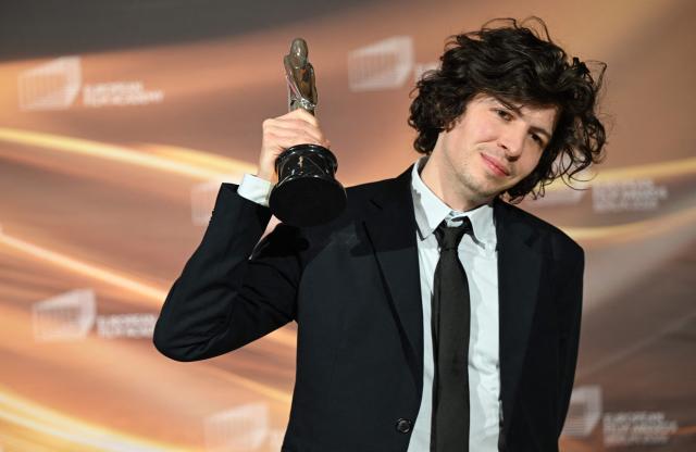 Winner of the European Animated Feature Film Award, French director and illustrator Ugo Bienvenu, celebrates with the trophy during the European Film Awards ceremony on January 17, 2026 in Berlin. (Photo by RALF HIRSCHBERGER / AFP)
