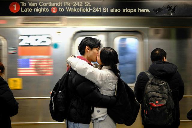 A couple kisses while waiting on a subway platform in New York on January 16, 2026. (Photo by CHARLY TRIBALLEAU / AFP)