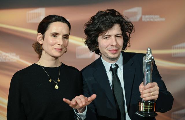 Winners of the European Animated Feature Film Award, French film producer Sophie Mas (L) and French director and illustrator Ugo Bienvenu, celebrate with the trophy during the European Film Awards ceremony on January 17, 2026 in Berlin. (Photo by RALF HIRSCHBERGER / AFP)