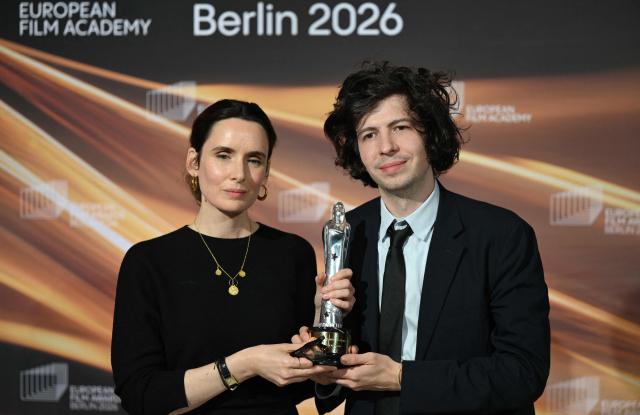 Winners of the European Animated Feature Film Award, French film producer Sophie Mas (L) and French director and illustrator Ugo Bienvenu, celebrate with the trophy during the European Film Awards ceremony on January 17, 2026 in Berlin. (Photo by RALF HIRSCHBERGER / AFP)