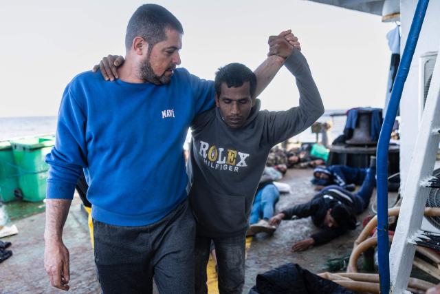 A crew member of the Sider, a merchant ship, helps a migrant suffering from severe dehydration and seasickness to be evacuated by crew members of the "Ocean Viking" rescue ship, in the search-and-rescue zone in international waters off the coast of Libya, on January 17, 2026. Crew members of the Ocean Viking rescue ship evacuated 44 migrants who had been rescued by a merchant ship a few days earlier in Libyas search-and-rescue zone in international waters. They were suffering from severe dehydration, seasickness, and a lack of medical care. Some were unable to walk and had to be evacuated on stretchers. They had left Libya a couple of days earlier aboard a fiberglass boat, hoping to reach the Italian coast before being shipwrecked in rough seas and rescued by a Tanzanian-flagged merchant ship. (Photo by Sameer Al-DOUMY / AFP)