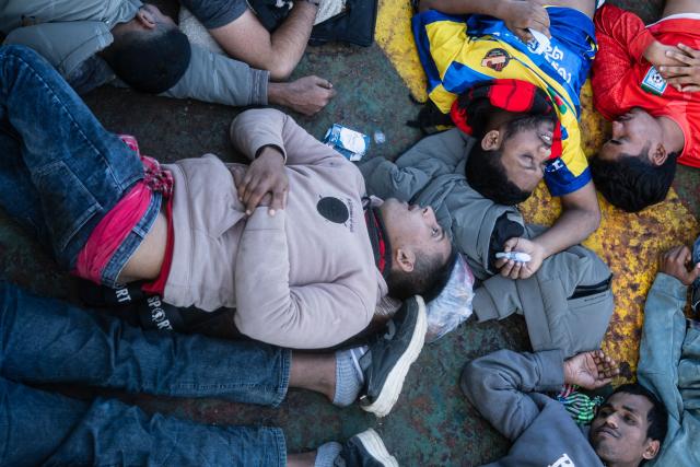 Migrants suffering from severe dehydration and seasickness lie on the floor onboard the Sider, a merchant ship, in the search-and-rescue zone in international waters off the coast of Libya, on January 17, 2026. Crew members of the Ocean Viking rescue ship evacuated 44 migrants who had been rescued by a merchant ship a few days earlier in Libyas search-and-rescue zone in international waters. They were suffering from severe dehydration, seasickness, and a lack of medical care. Some were unable to walk and had to be evacuated on stretchers. They had left Libya a couple of days earlier aboard a fiberglass boat, hoping to reach the Italian coast before being shipwrecked in rough seas and rescued by a Tanzanian-flagged merchant ship. (Photo by Sameer Al-DOUMY / AFP)