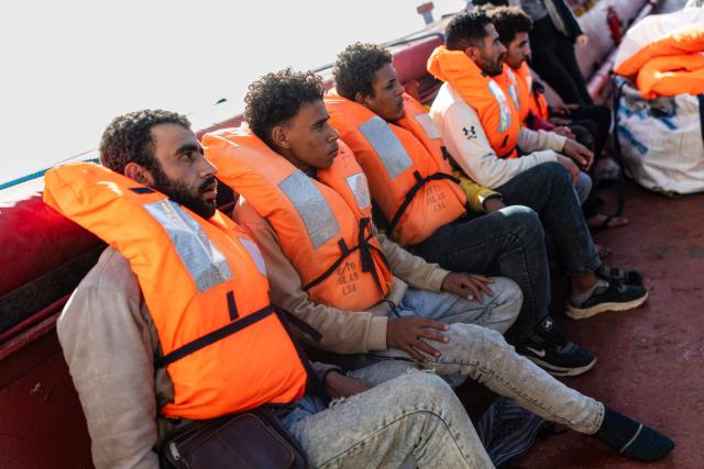 Migrants wearing life jackets wait to be evacuated from the Sider, a merchant ship, by crew members of the "Ocean Viking" rescue ship, in the search-and-rescue zone in international waters off the coast of Libya, on January 17, 2026. Crew members of the Ocean Viking rescue ship evacuated 44 migrants who had been rescued by a merchant ship a few days earlier in Libyas search-and-rescue zone in international waters. They were suffering from severe dehydration, seasickness, and a lack of medical care. Some were unable to walk and had to be evacuated on stretchers. They had left Libya a couple of days earlier aboard a fiberglass boat, hoping to reach the Italian coast before being shipwrecked in rough seas and rescued by a Tanzanian-flagged merchant ship. (Photo by Sameer Al-DOUMY / AFP)