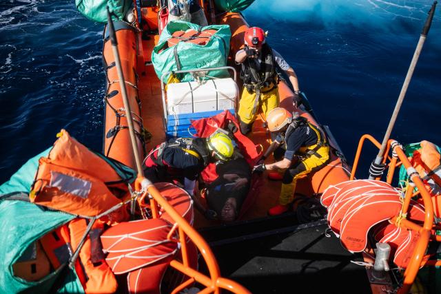 Crew members of the "Ocean Viking" rescue ship evacuates a migrant suffering from severe dehydration and seasickness, on a soft stretcher from the Sider, a merchant ship, using a RHIB (Rigid inflatable boat), in the search-and-rescue zone in international waters off the coast of Libya, on January 17, 2026. Crew members of the Ocean Viking rescue ship evacuated 44 migrants who had been rescued by a merchant ship a few days earlier in Libyas search-and-rescue zone in international waters. They were suffering from severe dehydration, seasickness, and a lack of medical care. Some were unable to walk and had to be evacuated on stretchers. They had left Libya a couple of days earlier aboard a fiberglass boat, hoping to reach the Italian coast before being shipwrecked in rough seas and rescued by a Tanzanian-flagged merchant ship. (Photo by Sameer Al-DOUMY / AFP)