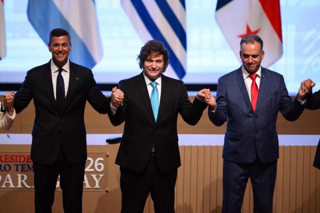 (L to R) Paraguay's President Santiago Pena, Argentina's President Javier Milei and Uruguay's President Yamandu Orsi pose for the official picture at the end of the signing ceremony of the trade agreement between the European Union and Mercosur, at the Gran Teatro Jose Asuncion Flores of Paraguay's Central Bank in Asuncion on January 17, 2026. The South American bloc Mercosur and the European Union on January 17 signed a major trade deal that has been 25 years in the making. (Photo by Luis ROBAYO / AFP)