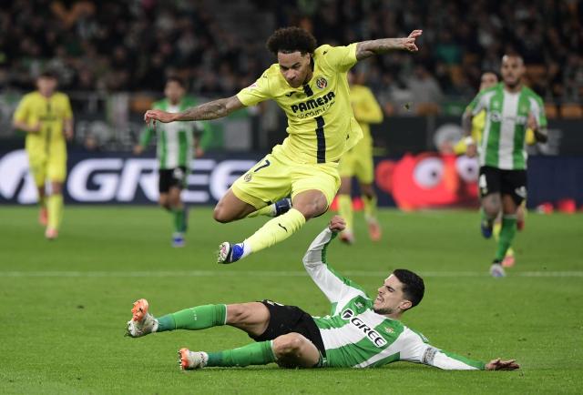Villarreal's Canadian midfielder #17 Tajon Buchanan (up) fights for the ball with Real Betis' Spanish defender #05 Marc Bartra during the Spanish league football match between Real Betis and Villarreal CF at Benito Villamarin Stadium in Seville on January 17, 2026. (Photo by CRISTINA QUICLER / AFP)