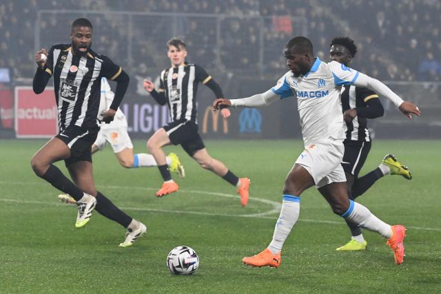 Marseille's Ivorian midfielder #20 Hamed Junior Traore (R) runs with the ball during the French L1 football match between SCO Angers and Olympique de Marseille (OM) at the Stade Raymond-Kopa in Angers, central Framce, on January 17, 2026. (Photo by JEAN-FRANCOIS MONIER / AFP)