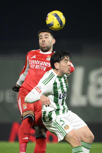 SL Benfica's Argentine defender #30 Nicolas Otamendi fights for the ball with Rio Ave's Greek defender #03 Nikos Athanassiou during the Portuguese league football match between Rio Ave FC and SL Benfica at Rio Ave FC - Dos Arcos stadium in Vila do Conde on January 17, 2026. (Photo by Miguel RIOPA / AFP)