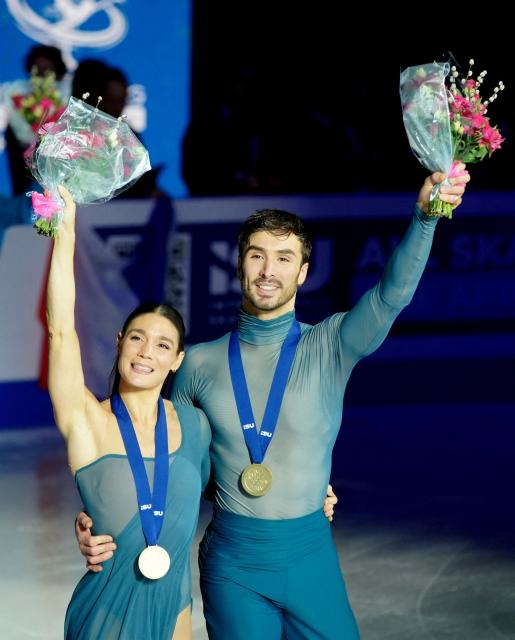 France's Laurence Fournier Beaudry and Guillaume Cizeron take part in a parade after their victory in the Ice Dance Free Dance on the final day of the ISU Figure Ice Skating European Championships in Sheffield, northern England on January 17, 2026. (Photo by Ian HODGSON / AFP)