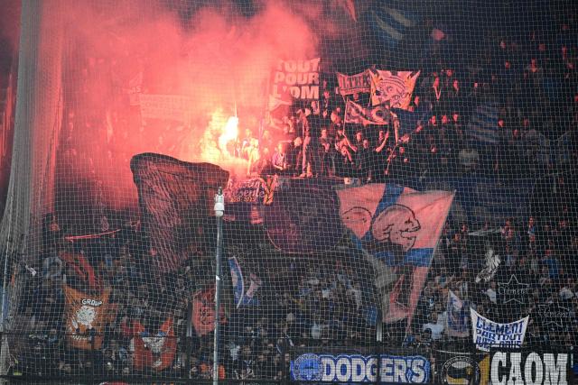 Marseille's supporters light flares during the French L1 football match between SCO Angers and Olympique de Marseille (OM) at the Stade Raymond-Kopa in Angers, central Framce, on January 17, 2026. (Photo by JEAN-FRANCOIS MONIER / AFP)