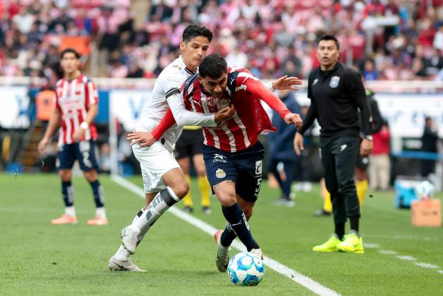 Queretaro's midfielder #12 Jaime Gomez (L) and Guadalajara's defender #05 Bryan Gonzalez (R) fight for the ball during the Liga MX Clausura football match between Guadalajara and Queretaro at the Akron Stadium in Zapopan, Mexico on January 17, 2026. (Photo by Ulises Ruiz / AFP)