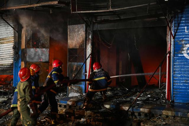 Firefighters douse a fire that broke out at a shopping mall in Karachi on January 18, 2026. (Photo by Rizwan TABASSUM / AFP)