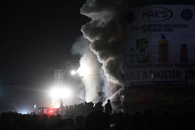TOPSHOT - Firefighters douse a fire that broke out at a shopping mall in Karachi on January 18, 2026. (Photo by Rizwan TABASSUM / AFP)