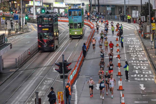 Runners take part in the half marathon race during the Hong Kong Marathon in Hong Kong on January 18, 2026. (Photo by ISAAC LAWRENCE / AFP)