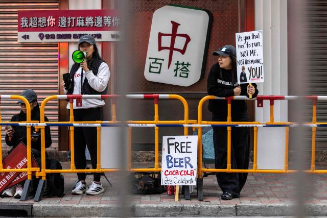Spectators cheer on runners during the Hong Kong Marathon in Hong Kong on January 18, 2026. (Photo by ISAAC LAWRENCE / AFP)