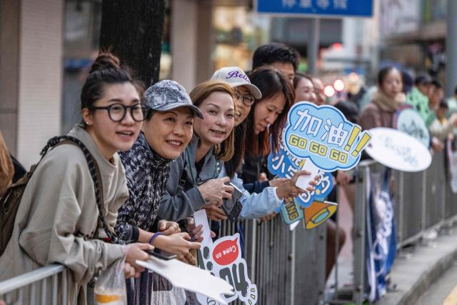Spectators cheer on runners during the Hong Kong Marathon in Hong Kong on January 18, 2026. (Photo by ISAAC LAWRENCE / AFP)