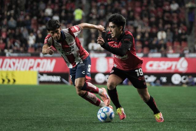 Tijuana's midfielder #19 Gilberto Mora (R) runs with the ball past San Luis' defender #02 Roman Torres (L) during the Liga MX Clausura football match between Tijuana and Atletico de San Luis at the Caliente Stadium in Tijuana, Baja California, Mexico on January 17, 2026. (Photo by Guillermo ARIAS / AFP)