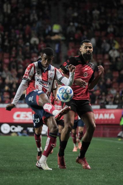 San Luis' defender #03 Robson Bambu (L) kicks the ball past Tijuana's Spanish forward #09 Mourad El Ghezouani (R) during the Liga MX Clausura football match between Tijuana and Atletico de San Luis at the Caliente Stadium in Tijuana, Baja California, Mexico on January 17, 2026. (Photo by Guillermo ARIAS / AFP)